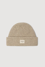 Beige knit beanie with a small label on a light gray background